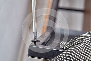 Handyman screws magnetic washer on metal furniture door