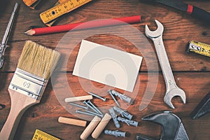 Handyman services home repair - blank business card with construction tools on wooden background photo