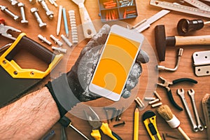 Handyman smartphone app, repairman holding mobile phone in hand