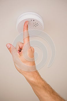 Handyman testing smoke detector