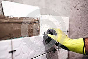 handyman, tiler applying ceramics on interior walls