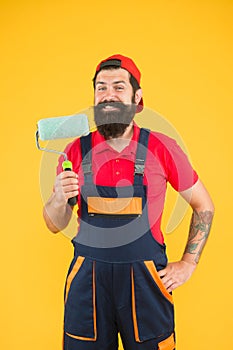 Handyman with tool. smiling erector assistant in work uniform. engineer designer ready to paint wall. repair concept photo