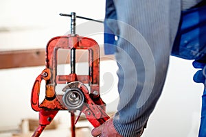 Handyman using wrench at industrial plumbing, construction site