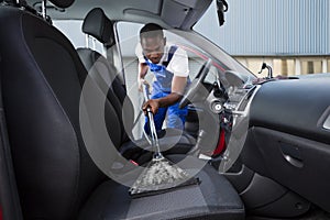 Handyman Vacuuming Car Front Seat