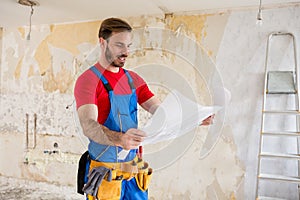 Handyman watchig blueprnts of home renovations