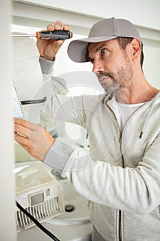 handyman wearing cap using screwdriver