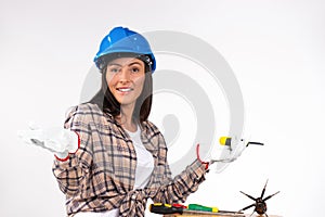 Handywoman electrician with screwdrivers and hardhat posing on white background