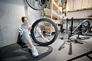 Handywoman reparing bicycle in the workshop