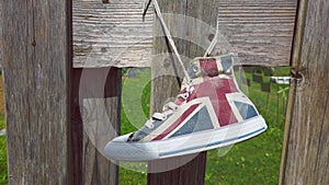 hang british flag sneakers shoes to fence - hipster shoes reuse in natural background