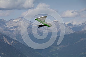 hang glider in the air with a backdrop of a blue mountain ridge