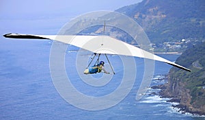 Hang glider flying over the ocean