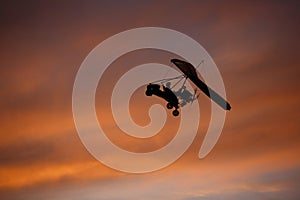 Hang-glider flying in red-pink sky