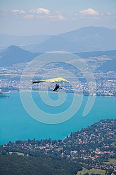 Hang-glider Instructor Flying in Hang-glider with Customer over Annecy Lake Through Mountain Landscape and Cities