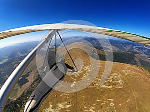 Hang glider pilot flies over mountain highlands in Slovakia