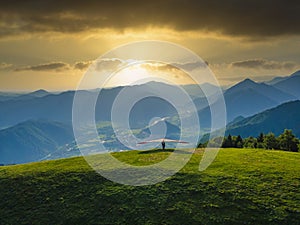 Hang glider ready to launch from the green meadow in the mountains