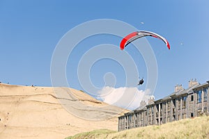 Hang Glider soars over beach lodging at Pacific City