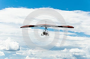 Hang gliding flight in blue sky with clouds