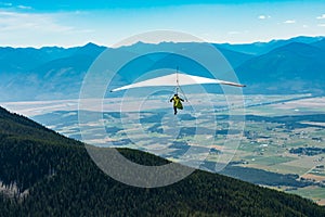 Hang gliding over valley farmlands and mountains