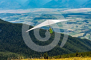 Hang gliding over valley farmlands and mountains