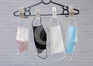 Hang a masks on a black straw rope on blick wall background,. Reuse in outbreak of COVID-19