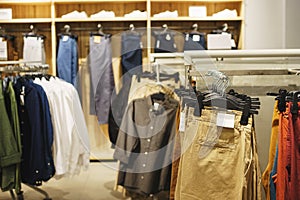 Hangers bright fashionable clothes. Trousers, blouses and shirts on a hanger clothing store close-up.