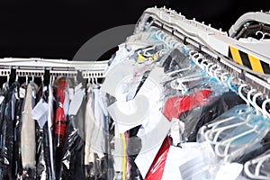 Hangers with clothes on conveyor at dry-cleaner`s