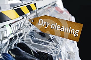 Hangers with clothes on garment conveyor at dry-cleaner`s