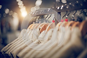 Hangers with clothes on the rail in the store. Shopping in store. Clothes on hangers in shop for sale