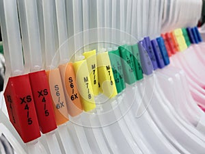 Hangers with color coded size tags in ascending order from smallest to largest.