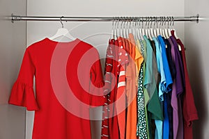 Hangers with different colorful clothes on rack