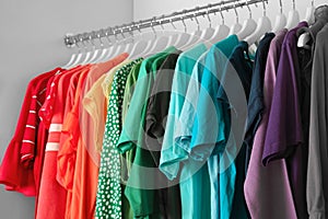 Hangers with different colorful clothes on rack