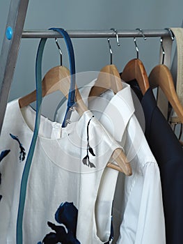 Hangers hangers with ceremonial male and female clothes. Light and blue clothes on a gray background