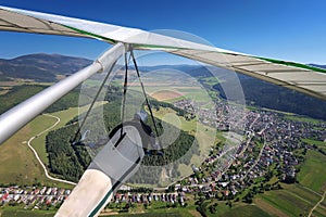 Hangglider pilot flies over small town in alpine valley