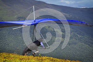 Hangglider take-off An athlete with a blue hang-glider prepares to start photo