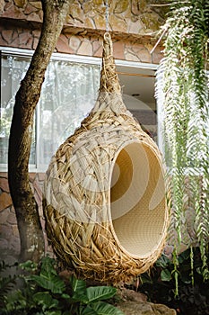 Hanging chair shaped into a bird`s nest to sit relax.