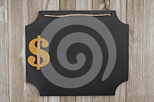 Hanging chalkboard with a dollar sign on weathered wood wall