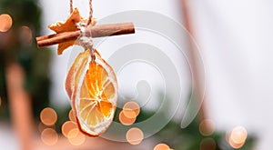 Hanging Christmas decoration of dried oranges, tangerine and cinnamon stars with copy space for text. holiday concept. blurred