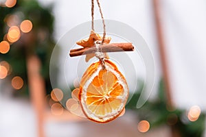 Hanging Christmas decoration of dried oranges, tangerine and cinnamon stars. holiday concept. blurred background