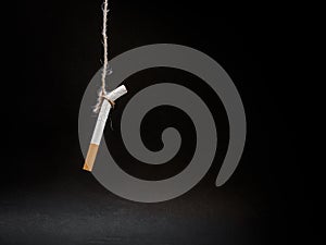 Hanging cigarete on black background. kill yourself. Quitting s