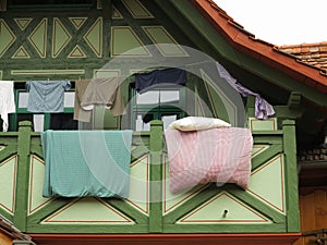 Hanging clothes and bedding over balcony