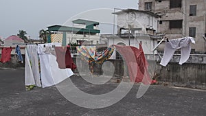 Hanging cloths on the rooftop are blowing in the wind on a cloudy afternoon.