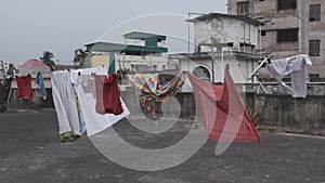 Hanging cloths on the rooftop are blowing in the wind on a cloudy afternoon.