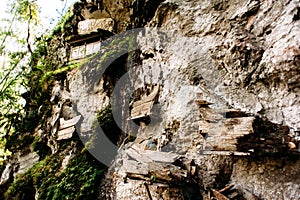 Hanging coffins, graves. Old coffin with skulls and bones nearby on a rock. Traditional burials site, cemetery Kete Kesu in Rantep