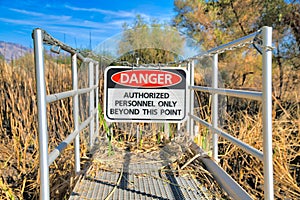 Hanging danger sign on a chainlink at Sweetwater Wetlands in Tucson, Arizona