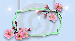 Hanging figured frame with branches of cherry blossoms. Twigs with flowers and buds on a blue backdrop. Background for spring or