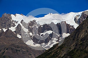 A hanging Glacier, peeking out over the forest, at the top of one of the mountains of the French Valley in Torres Del Paine Natio