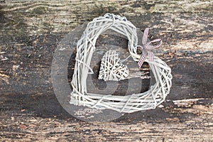 Hanging heart and wooden background in country style.