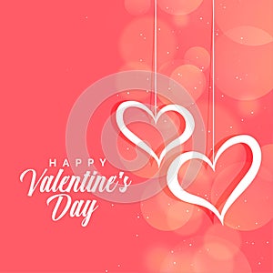 Hanging hearts on pink bokeh background for valentines day