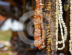 Hanging jewellery necklaces with coloured semi-precious stones, coloured stones and small white ivory pieces and amber