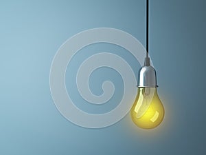 Hanging Light bulb glowing on dark cyan background